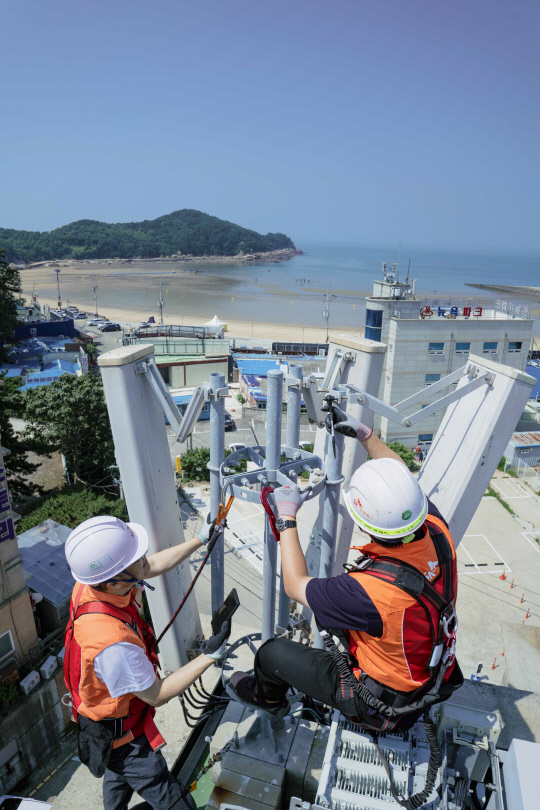 SKT와 SK오앤에스 현장 엔지니어들이 여름 휴가철 트래픽 증가에 대비해 인천 을왕리 해수욕장 기지국을 사전 점검하고 있다. SKT 제공